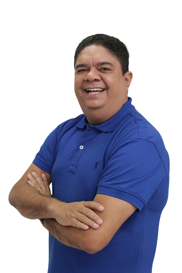 João Eduardo sorrindo, de camisa polo azul e braços cruzados